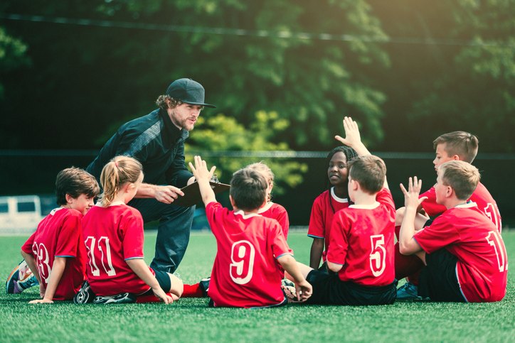 A coach talking young players through the moment before training